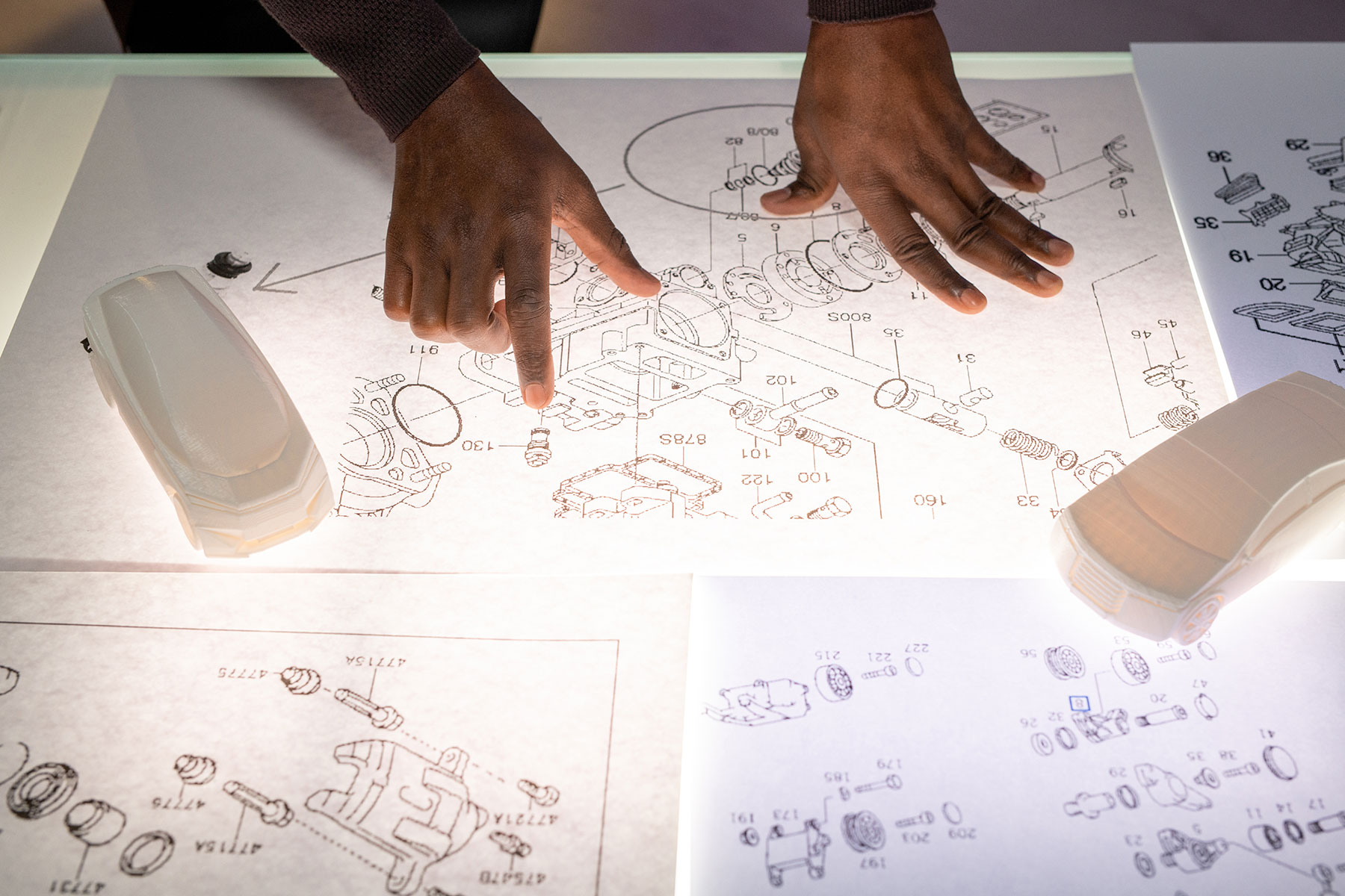 automotive-engineer-analyzing-sketches-2023-11-27-04-54-09-utc