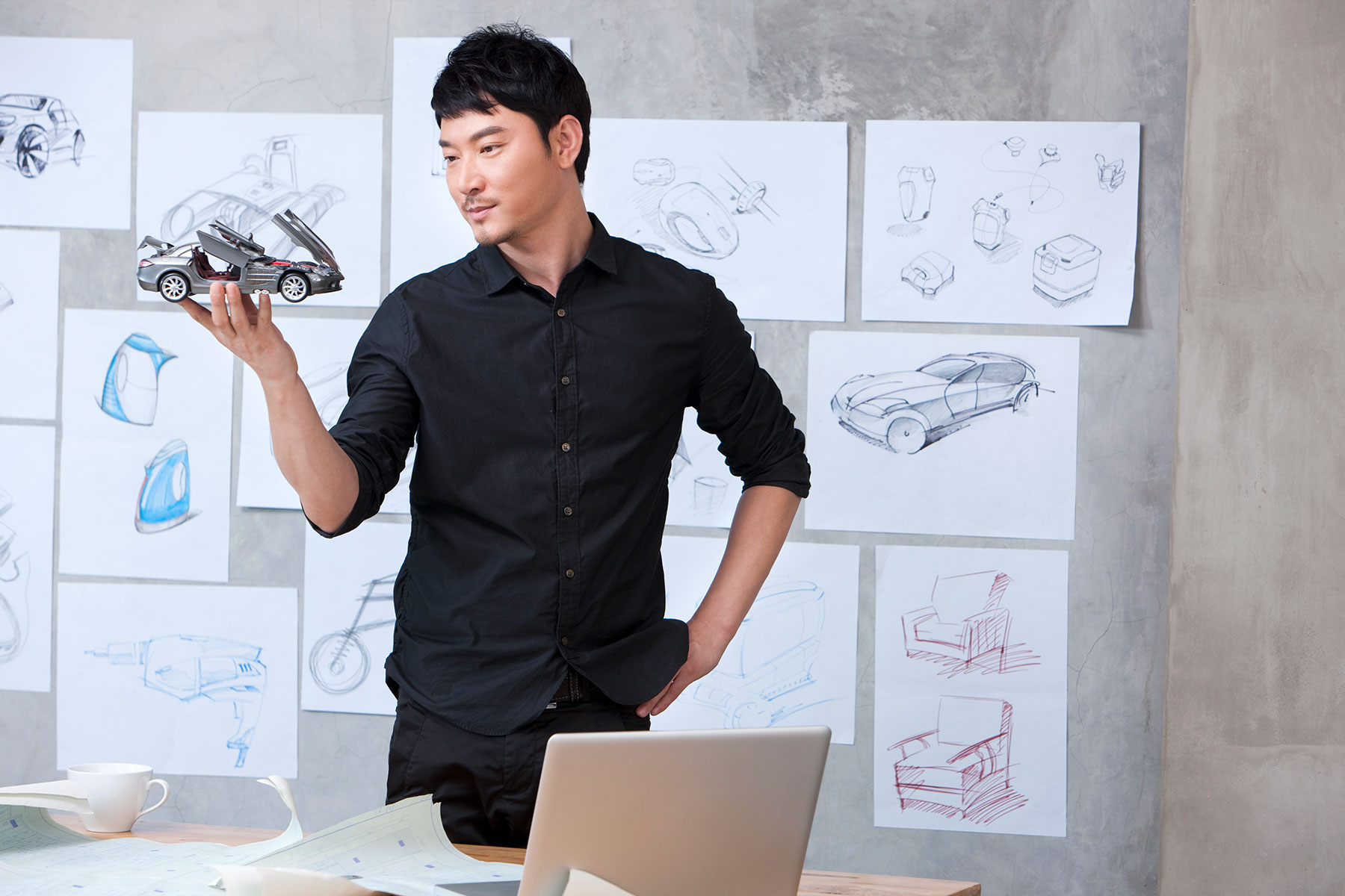 car-designer-holding-model-car-in-studio-2023-11-27-05-09-57-utc