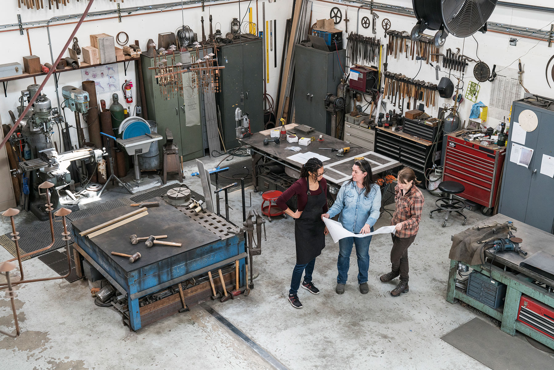 high-angle-view-of-three-women-standing-in-metal-w-2023-11-27-04-55-41-utc