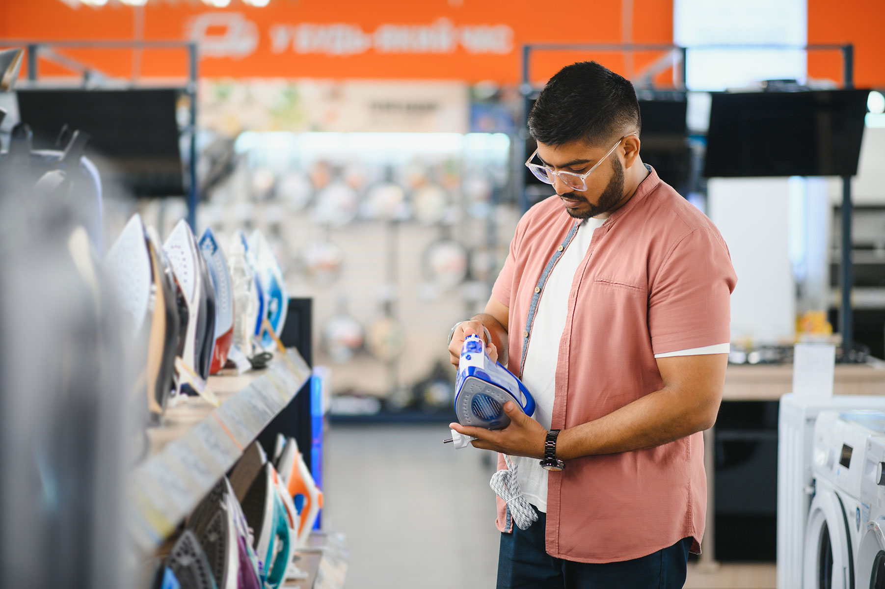 indian-man-choosing-electric-iron-at-store-2024-08-07-16-26-20-utc